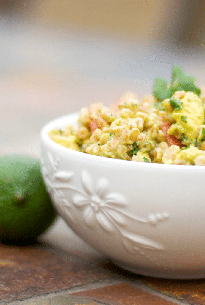 Guacamole Farro Salad in a white bowl with a lime. 