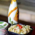 Mediterranean Pasta Salad in a bowl with dishes and silverware.