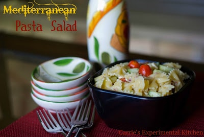 Mediterranean Pasta Salad in a bowl with plates and forks. 