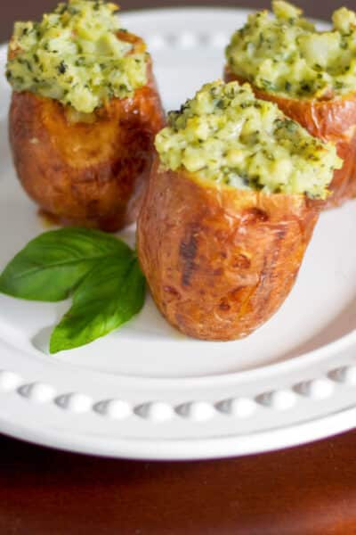 Stuffed baked potatoes made with fresh basil pesto and spices; then baked until super creamy and delicious makes a super flavorful side dish.