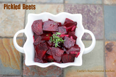 A close up of pickled beets in a white bowl.