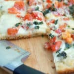 Caprese Flatbread closeup image on cutting board with knife