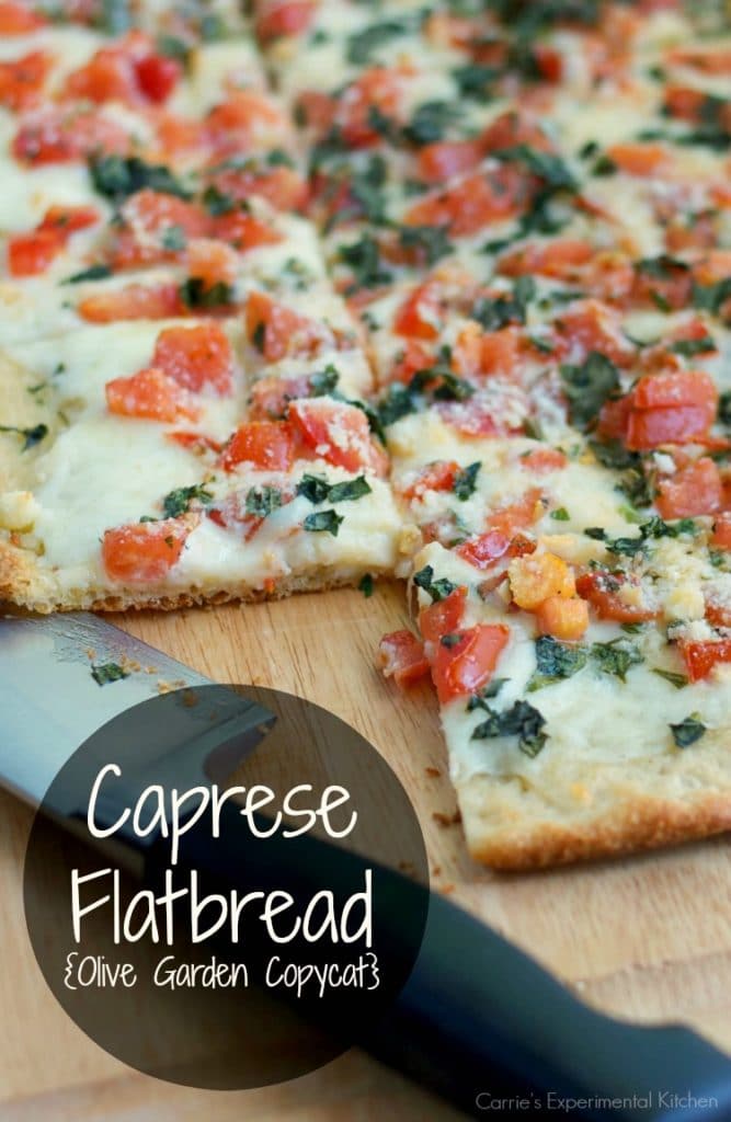 Flatbread made with fresh tomatoes, basil and mozzarella cheese on a cutting board. 