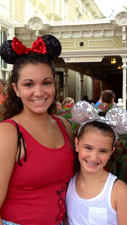 Two girls posing for the camera with mickey mouse ears on their heads