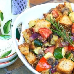 A bowl of food on a table, with Ratatouille and Bread