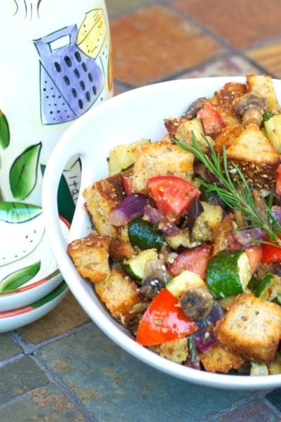 A bowl of food on a table, with Ratatouille and Bread