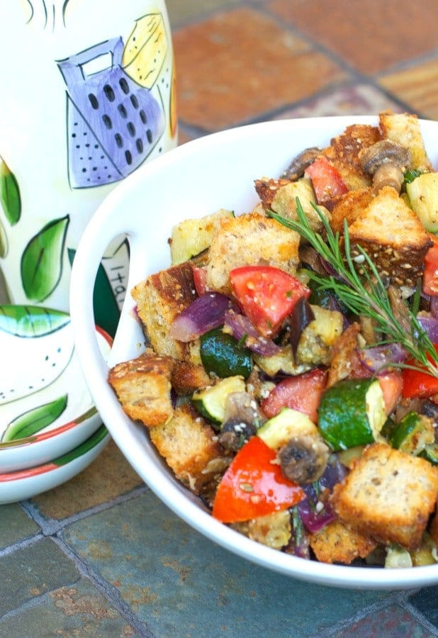 A bowl of food on a table, with Ratatouille and Bread