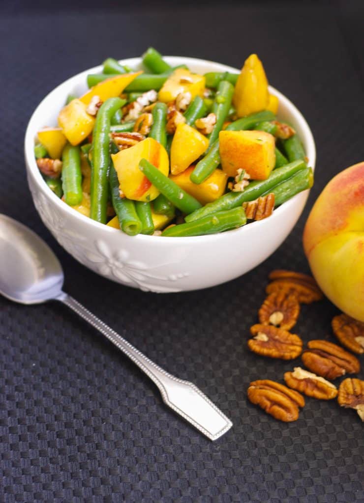 Fresh green beans and sliced peaches tossed with chopped pecans in a maple vinagrette is a delightfully flavorful Autumnal salad.