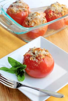 shrimp stuffed tomato on a plate with a fork