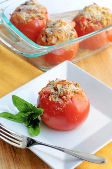 shrimp stuffed tomato on a plate with a fork