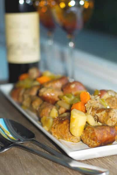 A plate of food on a table, with Sausage and Stew