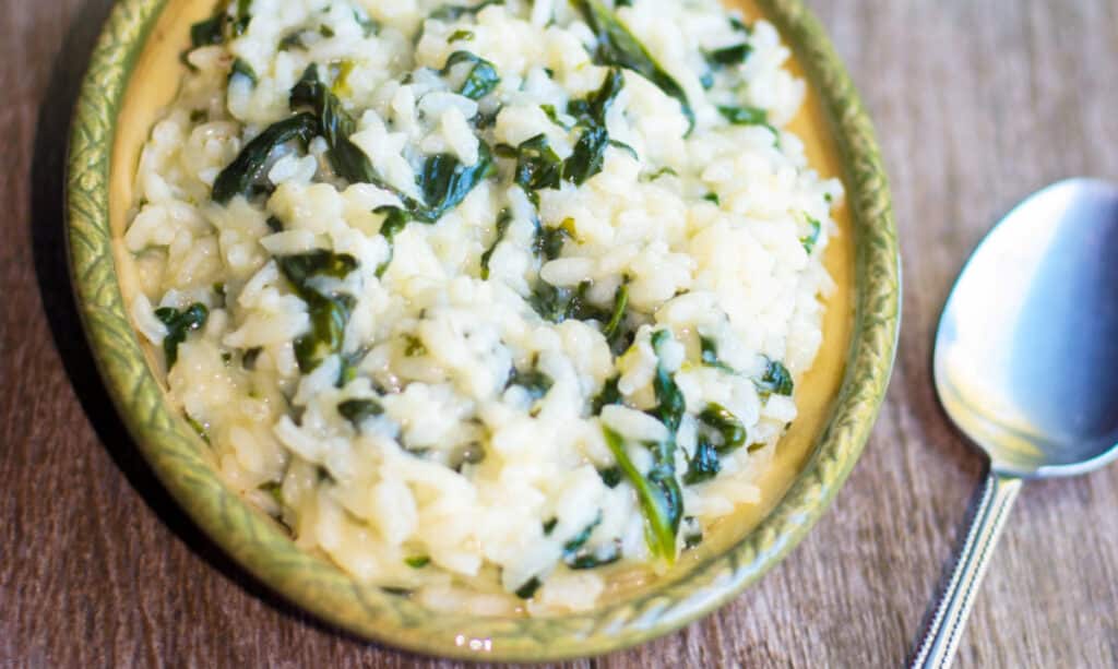 A close up of food on a wooden table, with Spinach Risotto 