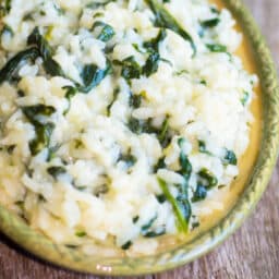 A close up of food on a wooden table, with Spinach Risotto