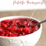 cranberry pear sauce in a white bowl with a spoon