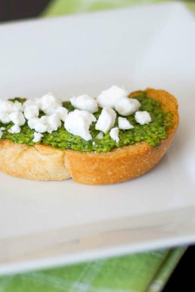 Pesto and Goat Cheese Crostini: Toasted baguette topped with fresh basil pesto and crumbled Goat cheese is a deliciously flavorful appetizer. 
