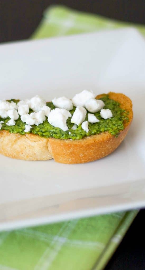 Pesto and Goat Cheese Crostini: Toasted baguette topped with fresh basil pesto and crumbled Goat cheese is a deliciously flavorful appetizer. 