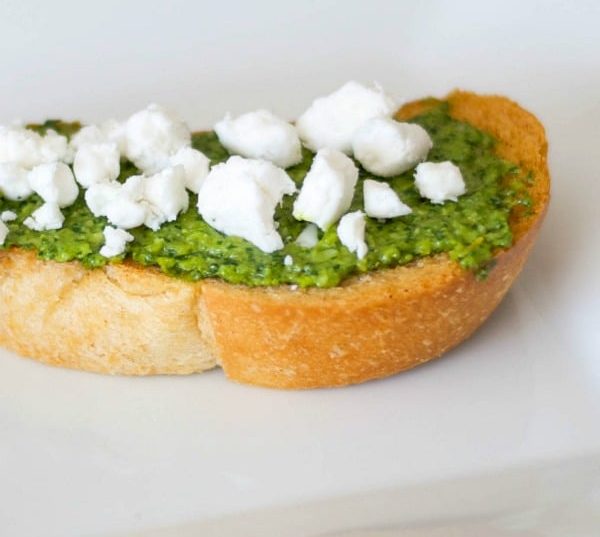 Pesto and Goat Cheese Crostini: Toasted baguette topped with fresh basil pesto and crumbled Goat cheese is a deliciously flavorful appetizer. 