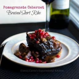 A plate of food on a table, with Pomegranate and Ribs