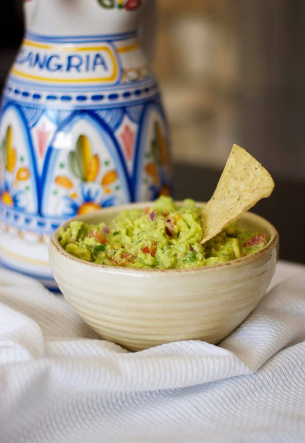 A bowl of food on a table, with Guacamole and Avocado
