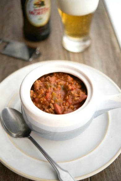 Beef chili with beer and vegetables in a soup crock.