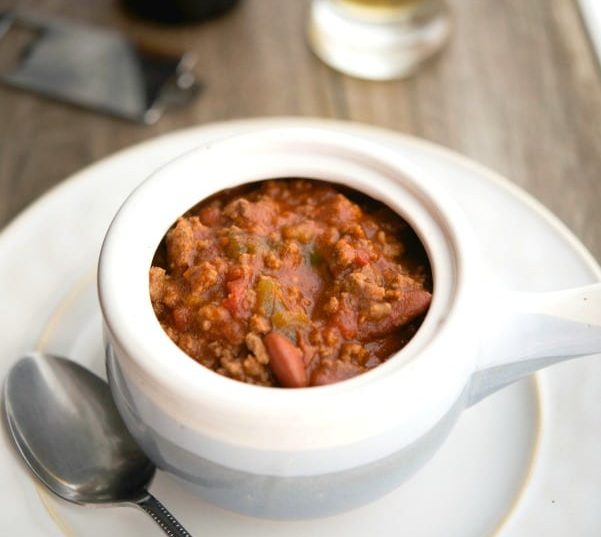 Beef chili with beer and vegetables in a soup crock.