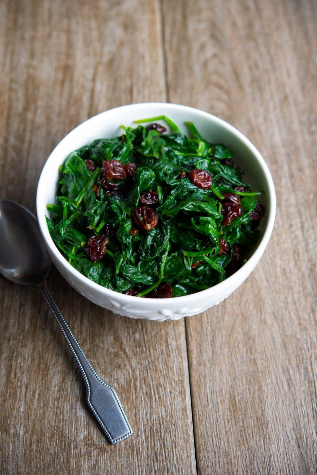 Fresh baby spinach sauteed with dried cherries is a tasty vegetable side dish that's ready in under ten minutes. #spinach #cherries #vegetable