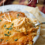 buffalo chicken dip in a dish with some on a spoon