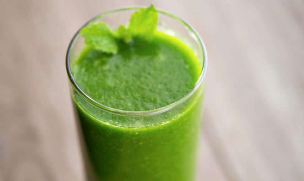 a close up of spinach smoothie in a glass