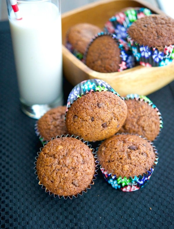 Hazelnut Chocolate Chip Banana Muffins on a table with milk. 
