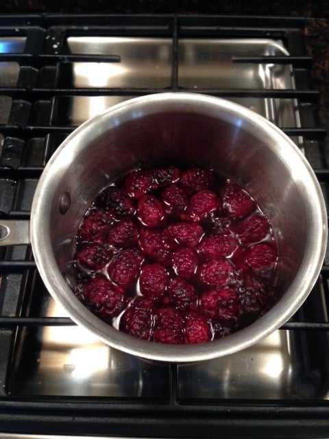 A pan of blackberries sitting on top of a stove in vinegar