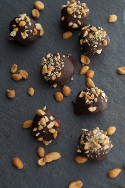 Dark Chocolate Nutter Butter Truffles in a row on slate.