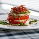 Caprese Stacks made with fresh mozzarella, Heirloom tomatoes and Italian prosciutto then topped with aged balsamic vinegar.