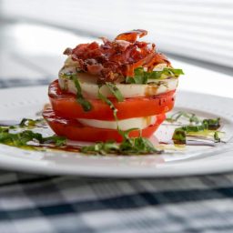 Caprese Stacks made with fresh mozzarella, Heirloom tomatoes and Italian prosciutto then topped with aged balsamic vinegar.