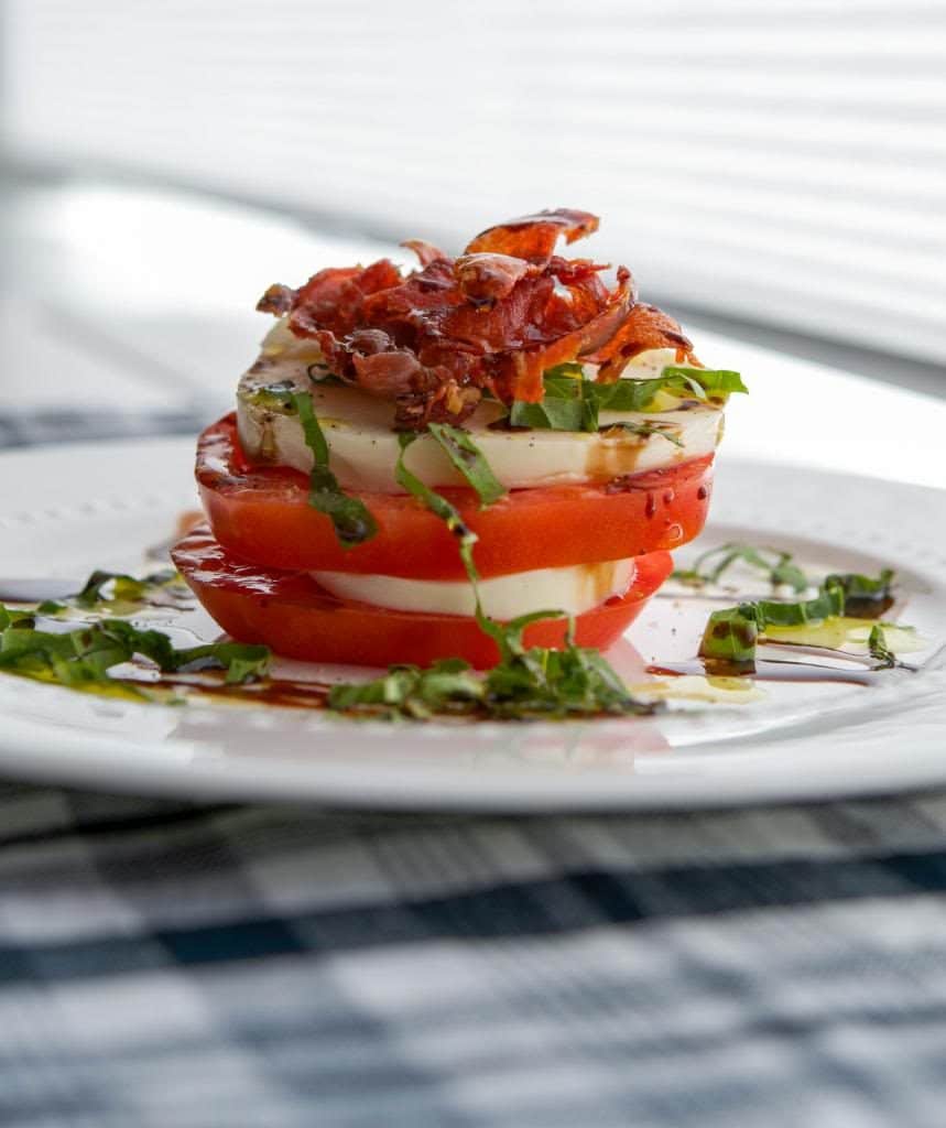 Caprese Stacks made with fresh mozzarella, Heirloom tomatoes and Italian prosciutto then topped with aged balsamic vinegar.