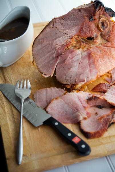 Bone-in ham on a wooden cutting board