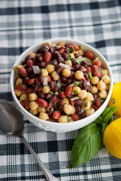 A bowl of Lemon-Basil Three Bean Salad on table with a spoon