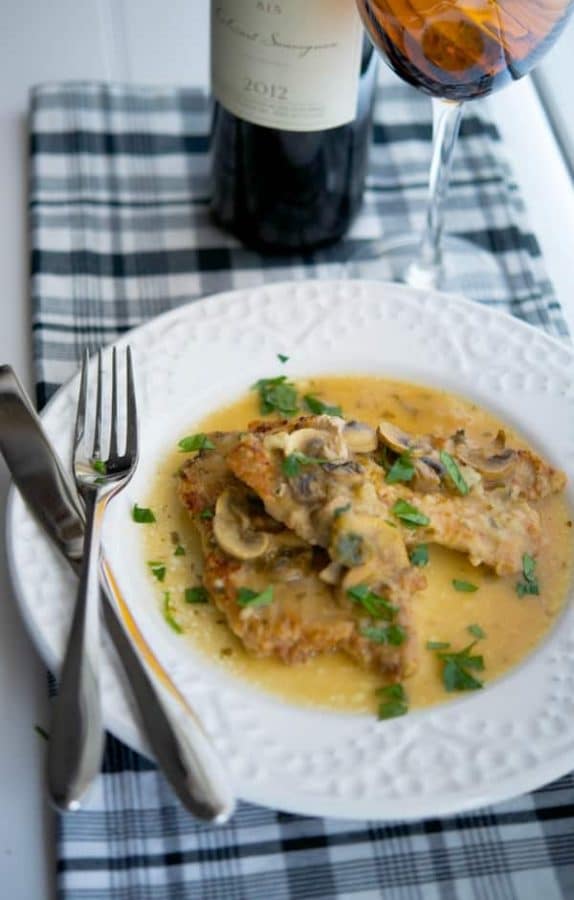 A plate of pork marsala with a fork