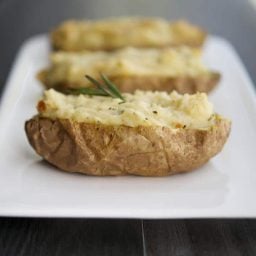 A close up of Roasted Garlic and Rosemary Twice Baked Potatoes on a plate.
