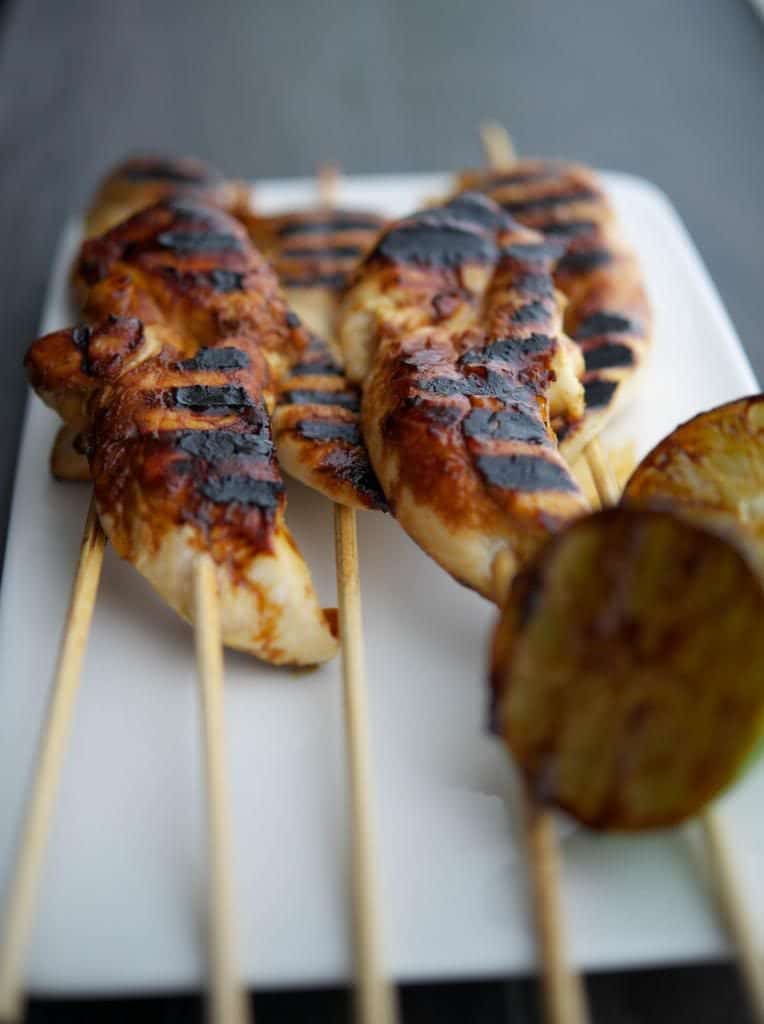A close up of grilled chicken skewers. 