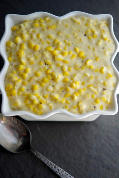 A close up of Garlic and herb creamed corn with a spoon