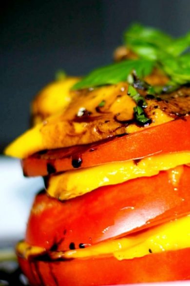 Sweet mangoes and fresh, ripened Heirloom Jersey tomatoes stacked, then topped with a balsamic reduction.