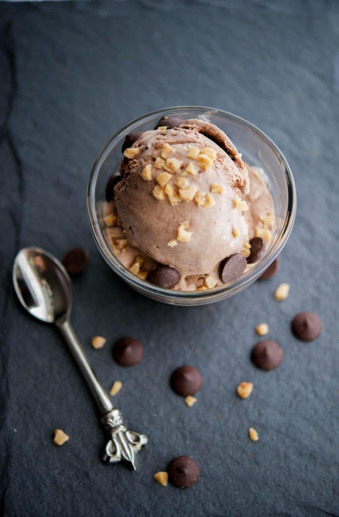 Chocolate Heath Bar Crunch Ice Cream in a glass dish with a spoon.