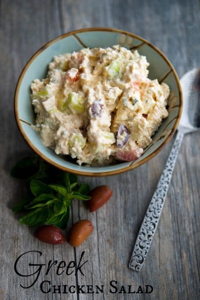 Greek style chicken salad in a bowl on a wooden table.