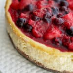 A close up of Vanilla Bean Cheesecake with Mixed Berry Compote.