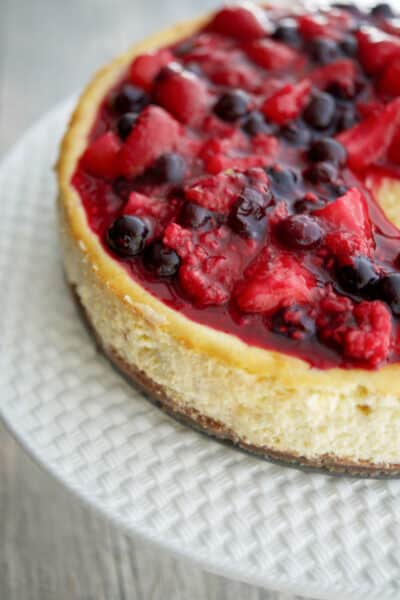 This Vanilla Bean Cheesecake made with cream cheese, Madagascar vanilla extract, vanilla beans, eggs, and sugar; then topped with a compote of fresh raspberries, strawberries and blueberries.