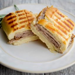 A roast beef sandwich cut in half on a plate