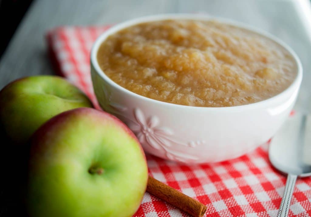 A bowl of applesauce on a table.