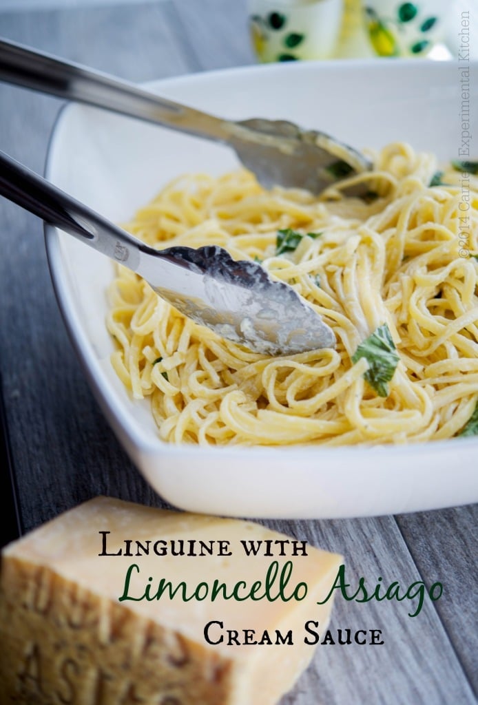 Linguine with Limoncello Asiago Cream Sauce in a white pasta bowl with tongs. 
