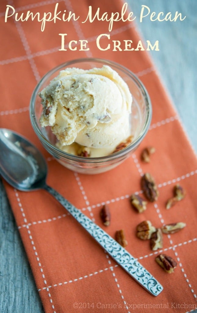 Pumpkin ice cream in a clear glass dish with a spoon. 