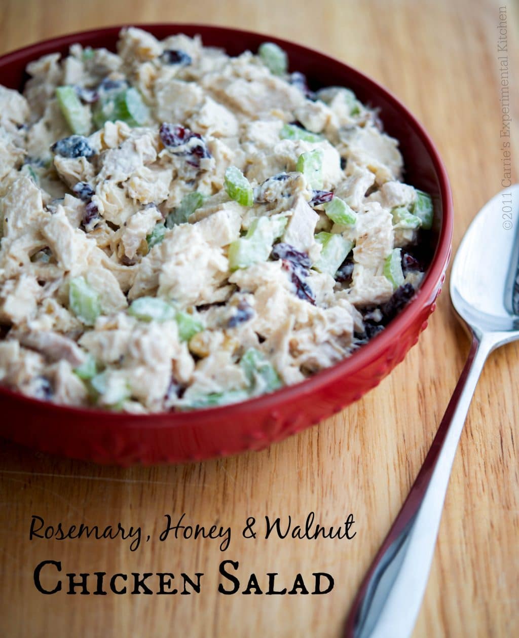 A bowl of chicken salad with a spoon 
